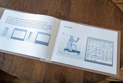 Pages of a book. An illustrated manual instructs the user how to construct a cardboard sculpture showing a kneeling man.